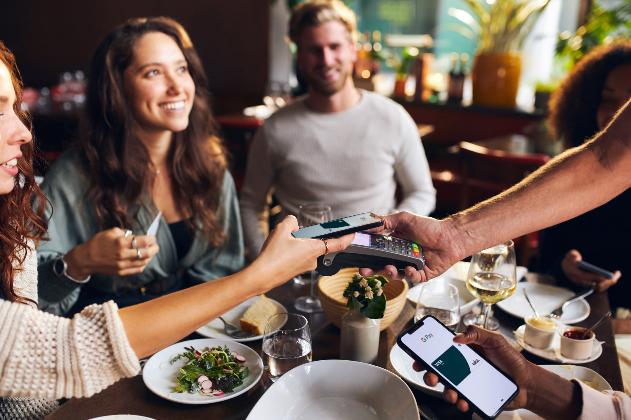 Dame betaler med mobilen på restaurant