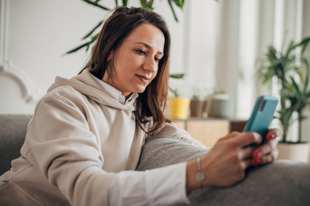 Kvinne ser på mobilen sin.
