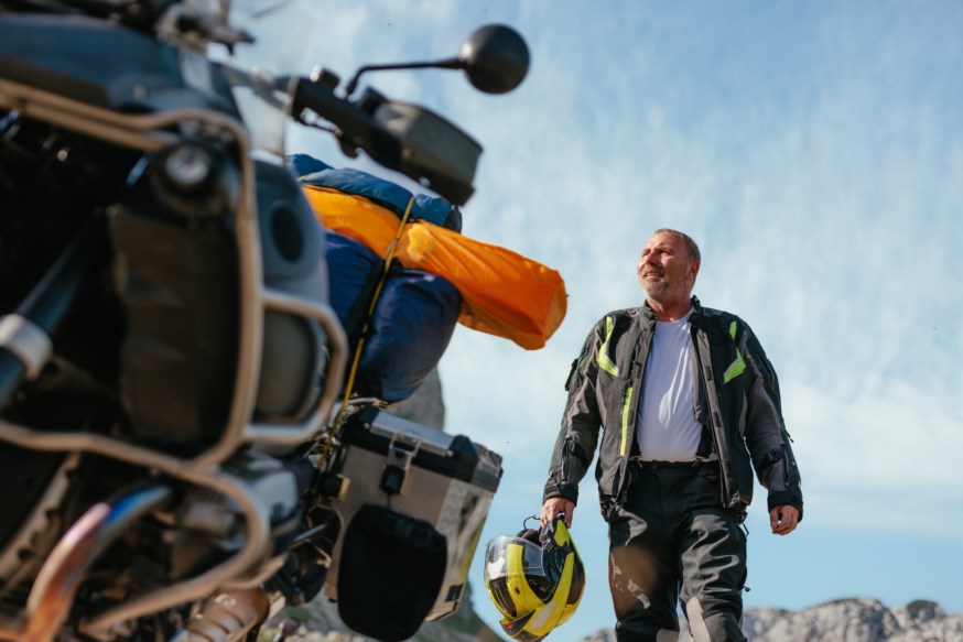 Mann på vei til å sette seg på motorsykkelen sin