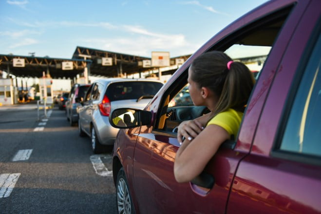 Dame venter i bilen på vei inn i et nytt land