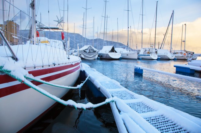 Båter ligger i havn på vinteren. Foto