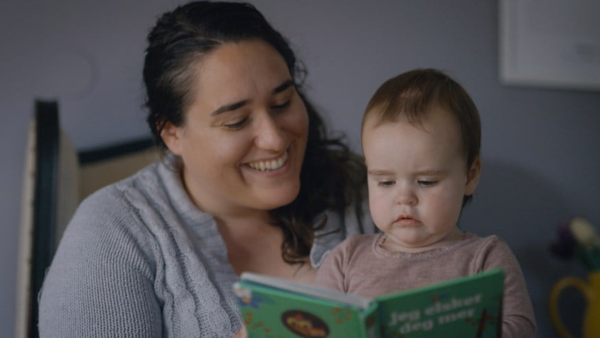 Mor og barn leser bok sammen. Foto