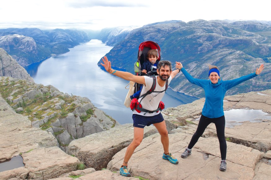 Et ektepar og deres lille barn på toppen av Preikestolen. foto