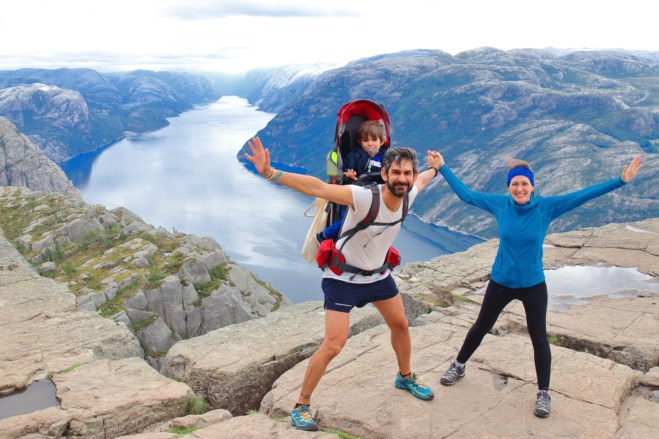 Et ektepar og deres lille barn på toppen av Preikestolen. foto