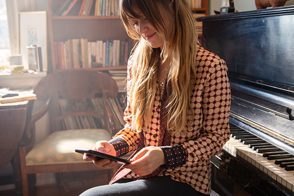 smilende kvinne ved piano